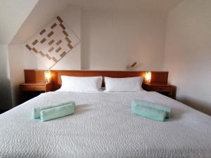 a bedroom with a bed with two green towels on it at Domstadt Apartments in Merseburg
