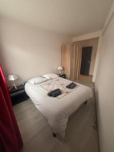 a bedroom with a large bed with white sheets at La petite récréation, Place de parking inclus in Dieppe