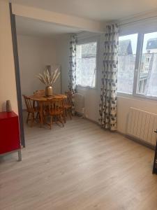 a dining room with a table and a table and chairs at La petite récréation, Place de parking inclus in Dieppe