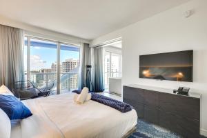 a bedroom with a large bed and a large window at Walk to A1A and Beach Park Fort Lauderdale Oasis! in Fort Lauderdale +18 photos
