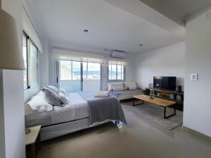 una camera da letto con un letto grande e un soggiorno di Delta Boutique Loft, en el centro de Salta, p/ 3 a Salta