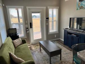 a living room with a couch and a coffee table at Texoma Getaway - Tiny House on a Pharm in Cartwright