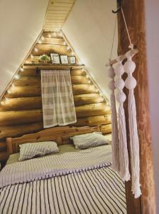 a bedroom with a bed with a wooden wall at Lambievi Kolibi in Gorno Kraishte