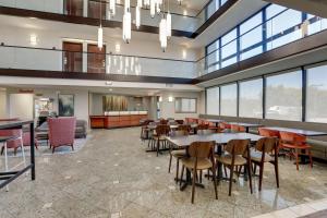 a dining room with tables and chairs and windows at Drury Inn & Suites Charlotte University Place in Charlotte
