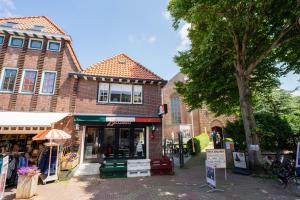 a building with a store on a street at Studio Augusta in Den Burg