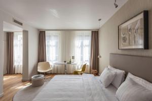 a room with a bed, chair, table and window at Casati Budapest Hotel Superior - Adults Only in Budapest