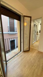 Una habitación vacía con una puerta corrediza de vidrio y un balcón. en AZAHAR MUSEO, en Sevilla