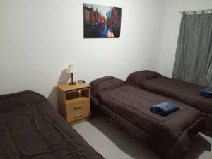 a room with two beds and a night stand with a bedskirts at Casita de Rada Tilly in Escalante