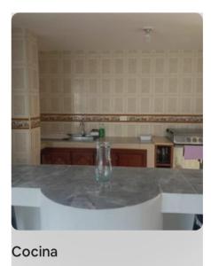 a kitchen with a table with a bottle on it at apartamento dúplex con piscina en el Rodadero in Rodadero