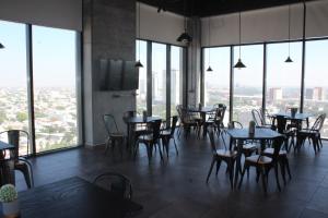 a restaurant with tables and chairs and large windows at Hotel Ecovergel Santa Lucia in Monterrey