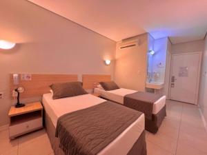 a hotel room with two beds in a room at Igaras Hotel in Otacílio Costa