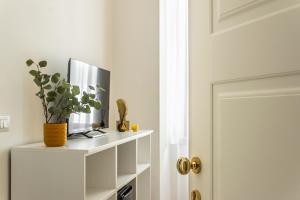 a tv on a white shelf next to a door at Al CASTELLO AVEZZANO in Avezzano