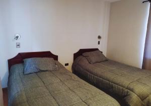 two beds sitting next to each other in a bedroom at Hostería Valle Verde in Villa Alemana +36 photos