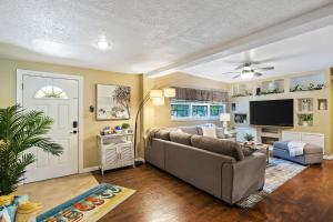 a living room with a couch and a tv at Seminole Shores Private Pool Outdoor Games Wifi in Redington Shores +39 photos