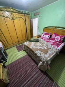 a bedroom with a bed with pink pillows on it at Apartment in Portsaid Sea view in Port Said