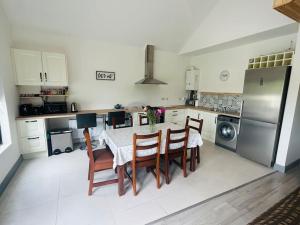 a kitchen with a table and chairs and a refrigerator at Hillview Lodge in Barrysbrook