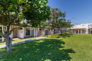 a green yard with trees in front of a building at LA CASABONITA vistalberca AirA in Alpuyeca