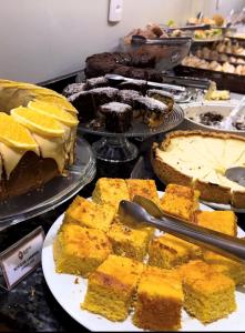 a display of cakes and other desserts on a table at Igaras Hotel - Centro de Otacílio Costa, 49km de Lages in Otacílio Costa +61 photos
