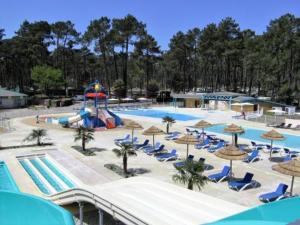 a pool with a water park with chairs and a slide at O'ContisParadise in Saint-Julien-en-Born