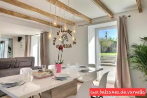 een eetkamer met een witte tafel en stoelen bij Piscine intérieure privée chauffée spa toute lannee disponible minimum 2 nuits in Ploudaniel