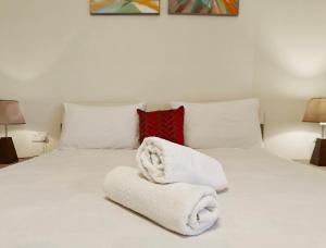 a bedroom with a white bed with towels on it at Seaside 3 in Marsaskala
