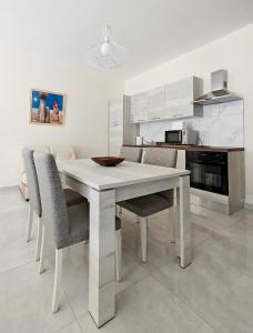 a white dining room table and chairs in a kitchen at Seaside 3 in Marsaskala