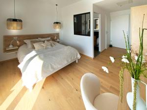 a bedroom with a large bed and a chair at L'Escapade vintage in Eschau