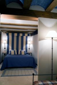 1 dormitorio con 1 cama con rayas azules y blancas en La Casa del tío Americano en Albarracín