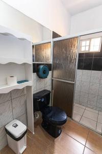 a bathroom with a black toilet and a shower at Casa 3 habitaciones Salida al Aeropuerto in San Pedro Sula +26 photos