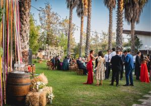 a group of people standing in the grass at a wedding at Hostería Valle Verde in Villa Alemana