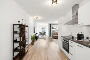 a kitchen and living room with white walls and wooden floors at Nexstay Studio mit Terrasse & Parkplatz für 4 in Neumarkt in der Oberpfalz
