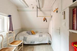 a small bedroom with a bed and a chair at Gite Chez Marcel in Riquewihr