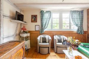 a living room with two chairs and a window at Gite Chez Marcel in Riquewihr
