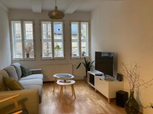 Una sala de estar con un sofá y un televisor. en Anno 1577 - Marktkirchhof 6, en Quedlinburg