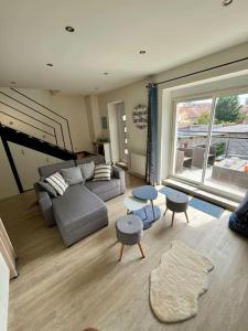a living room with a couch and tables and a window at Charmant appartement à Roanne in Roanne