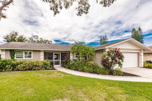 a house with a green lawn at Grinning Gecko 4Bdr3Bath NEW Pool House, Heated Salt Pool, Indoor-Outdoor Kitchen and Fireplaces, Putting Green, Bocce Court-Within 6 miles of AMI in Bradenton