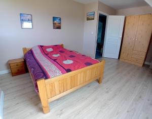1 dormitorio con cama de madera y manta roja en Gîte du Buron 6 8 personnes, en Longueville