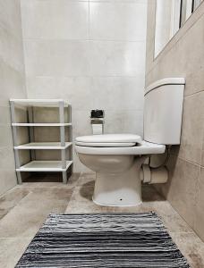 a bathroom with a toilet and a rug at Seaside 4 in Marsaskala