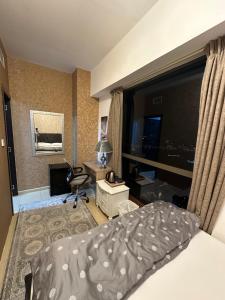a bedroom with a bed and a desk and a window at Fabulous Palm View in Dubai +30 photos