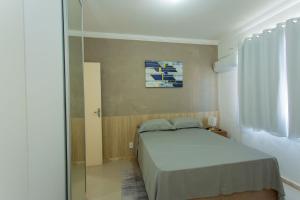 a small bedroom with a bed and a window at Apto com ar-condicionado a 350m do mar em Aracaju in Santa Maria
