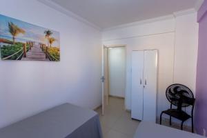 a bedroom with a bed and a chair and a picture at Apto com ar-condicionado a 350m do mar em Aracaju in Santa Maria