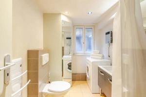 a bathroom with a toilet and a sink and a washing machine at Gite Chez Marianne in Riquewihr +35 photos