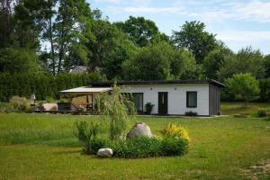 a small white house in the middle of a field at Holiday Home Rubini in Līvi