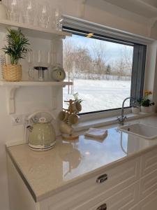 a kitchen counter with a sink and a window at Holiday Home Rubini in Līvi