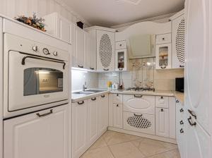 a white kitchen with white cabinets and a microwave at House in Lviv in Lviv
