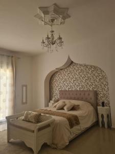a bedroom with a large bed and a chandelier at Villa Romana Monastir in Monastir +52 photos