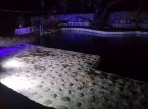 a stage with a pool of water with purple lights at Casa Campestre El Silencio con Familias Exitosas in Rivera +12 photos