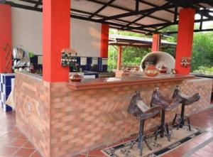 a kitchen with a counter with stools in front of it at Casa Campestre El Silencio con Familias Exitosas in Rivera