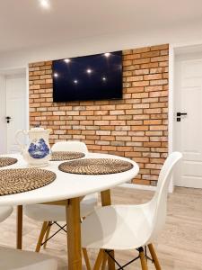 a dining room with a white table and chairs at Domek z ogrzewaniem podłogowym in Wyszki