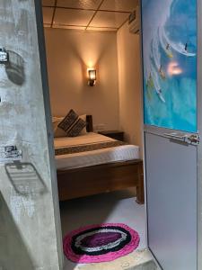 ディックウェラにあるMountain Peak Homestay Hiriketiyaの小さなベッドルーム(ベッド1台、冷蔵庫付)